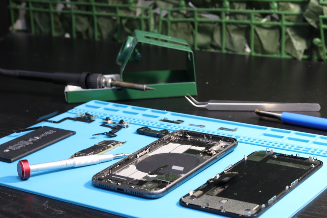 Phone parts and repair tools are on a mat.