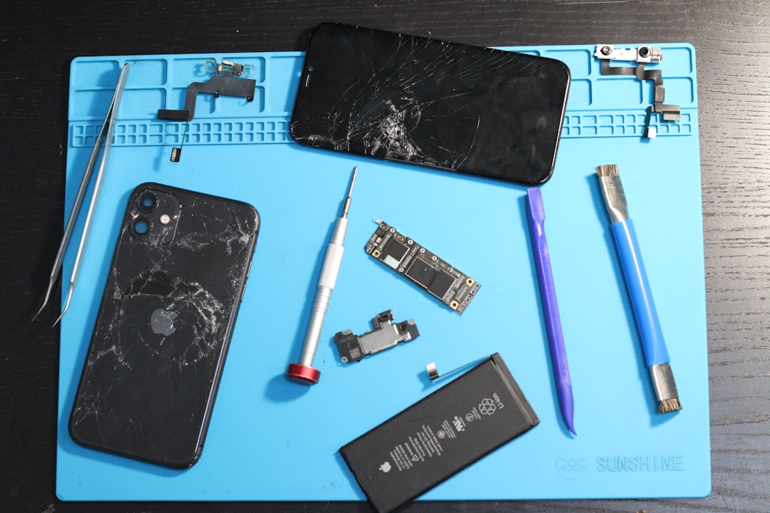 Cracked iphones and repair tools arranged on a mat.