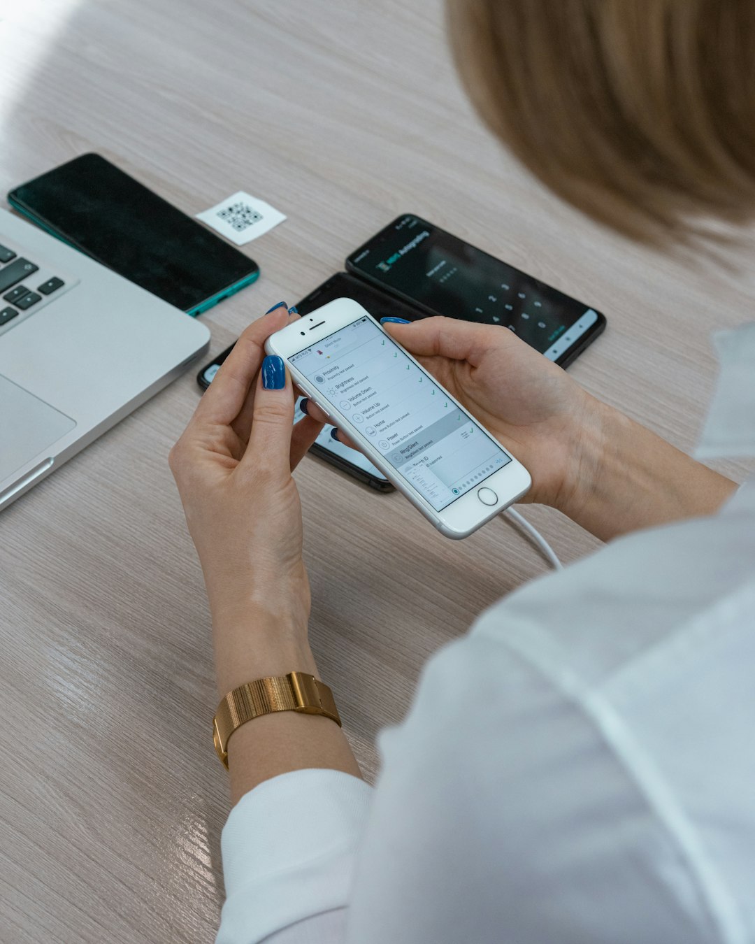 a woman sitting at a table using a cell phone