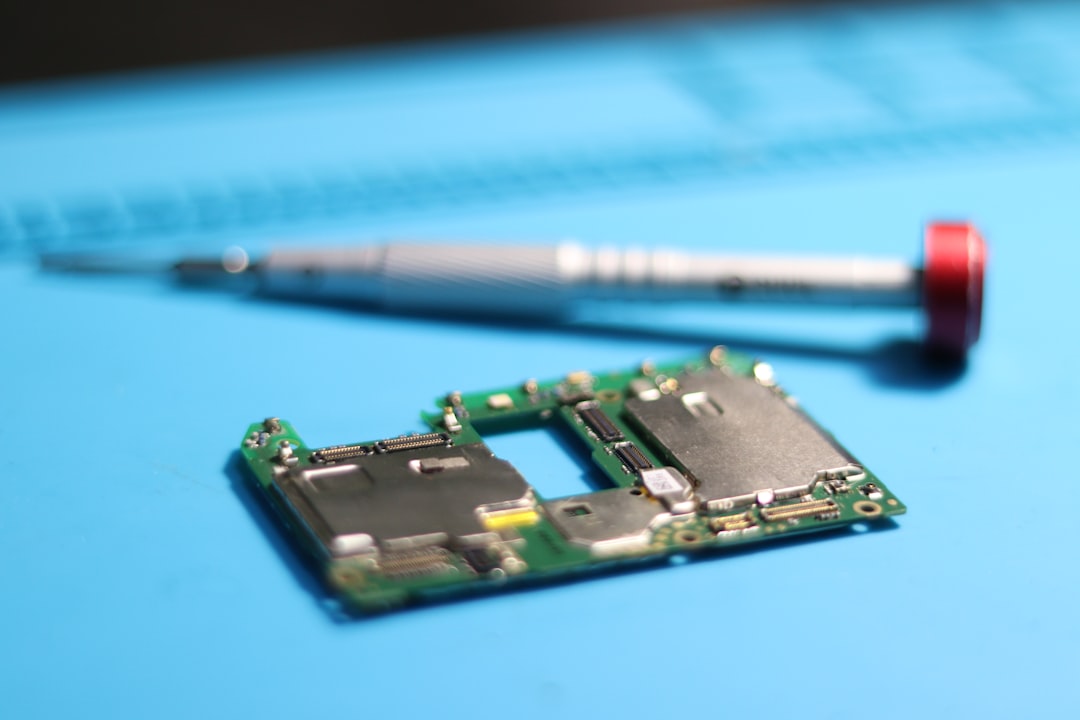 Circuit board being repaired with a screwdriver.