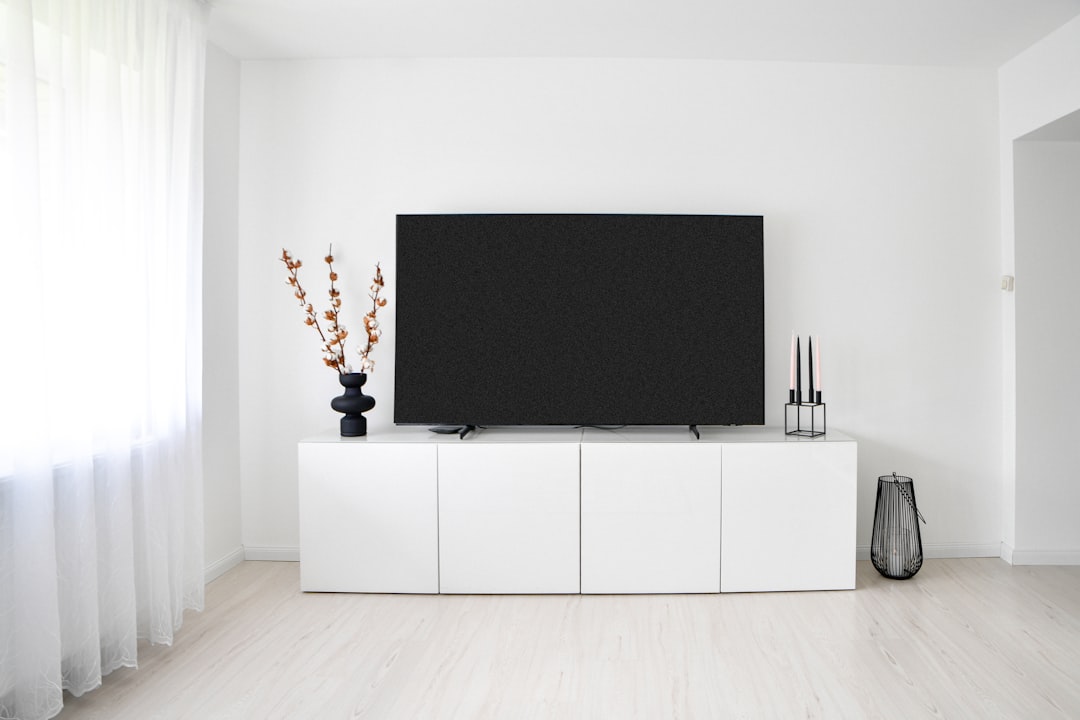 White minimalist room with television and storage cabinet.