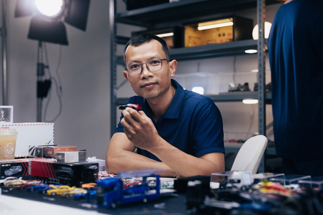Man in glasses sitting at a desk with items