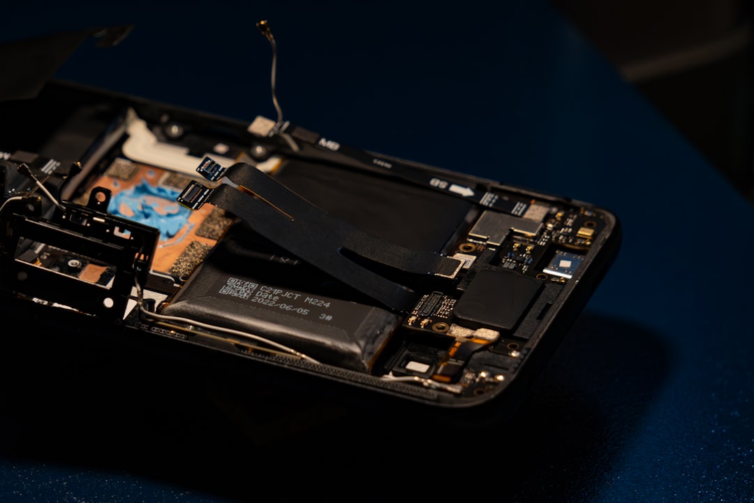 Disassembled smartphone showing internal electronic components and battery.