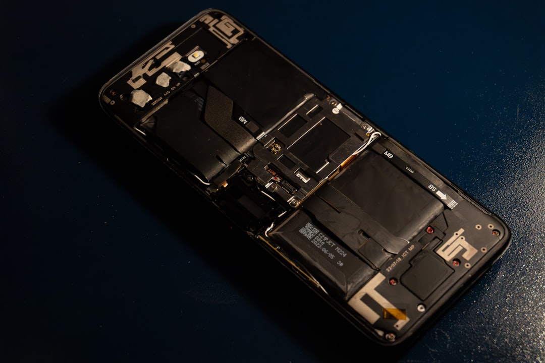 Internal components of a disassembled smartphone on a dark surface.
