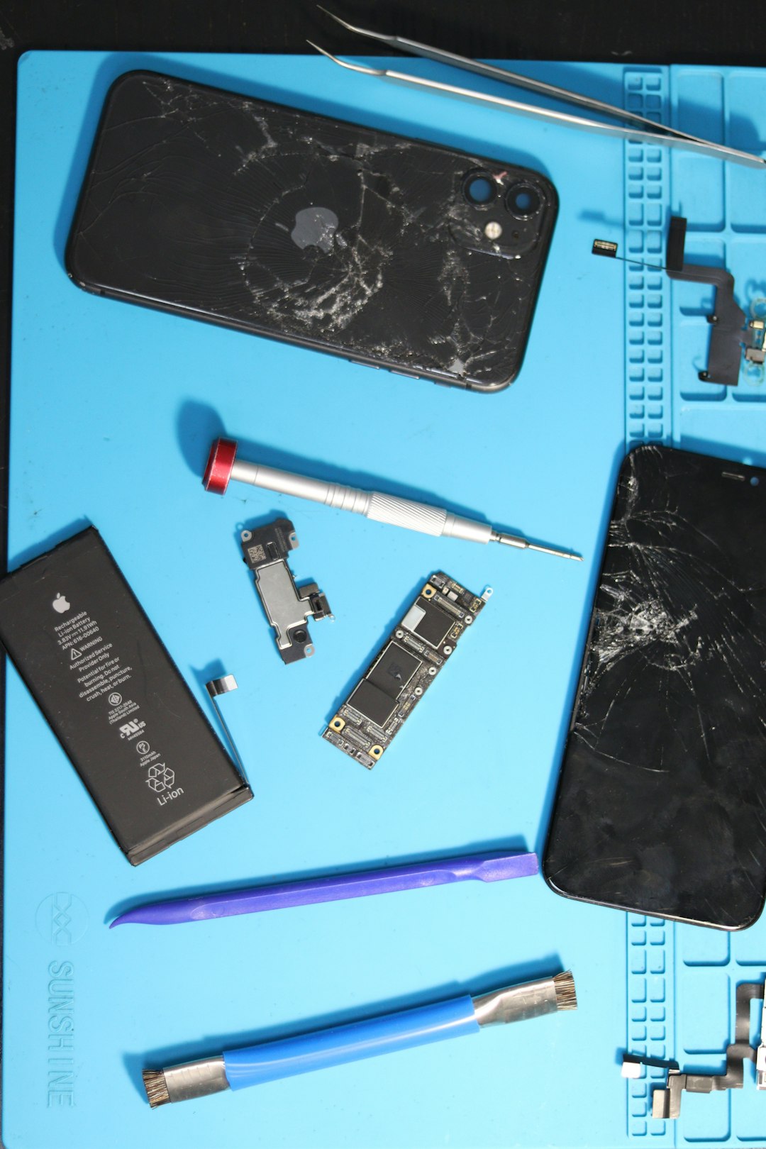 A broken phone is being disassembled for repair.