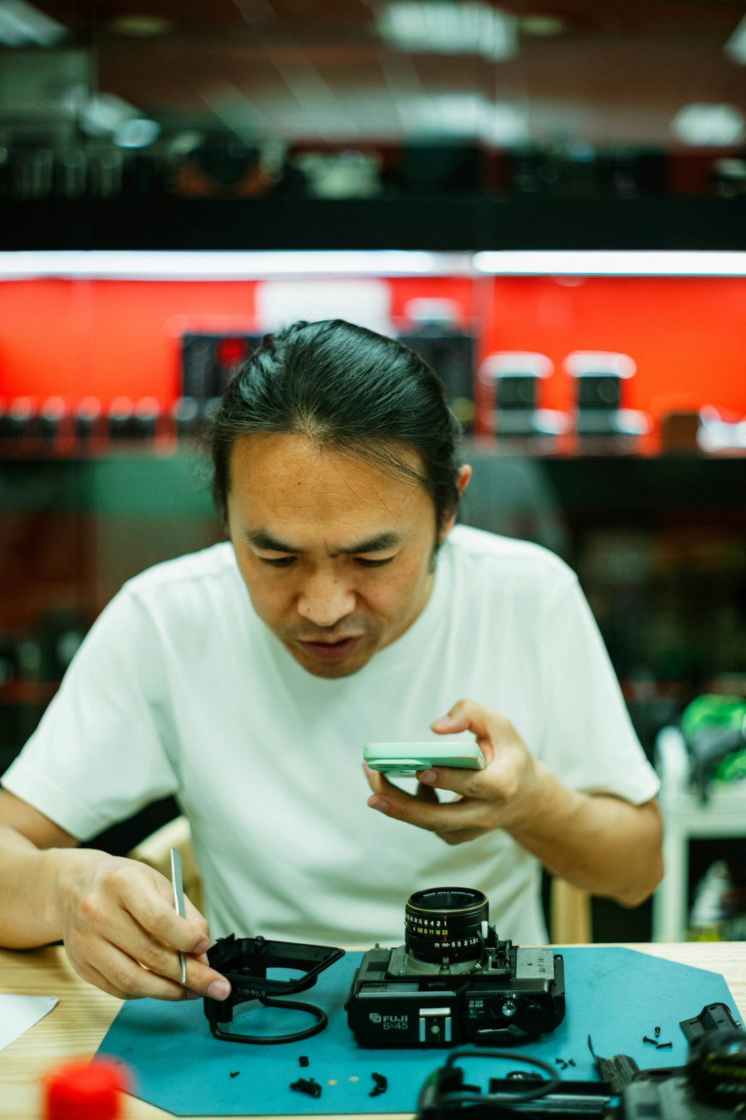 A man carefully repairs a camera.