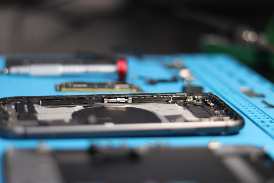 A smartphone is disassembled on a workbench.