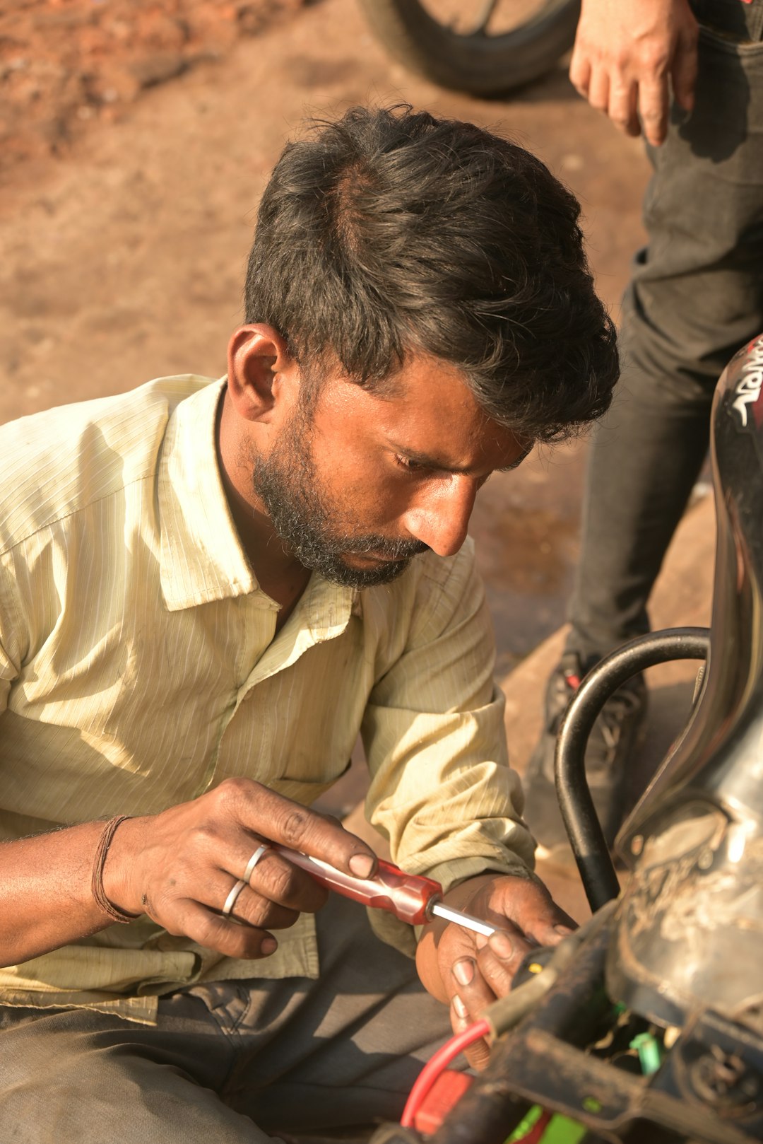 A man sitting on the ground working on something